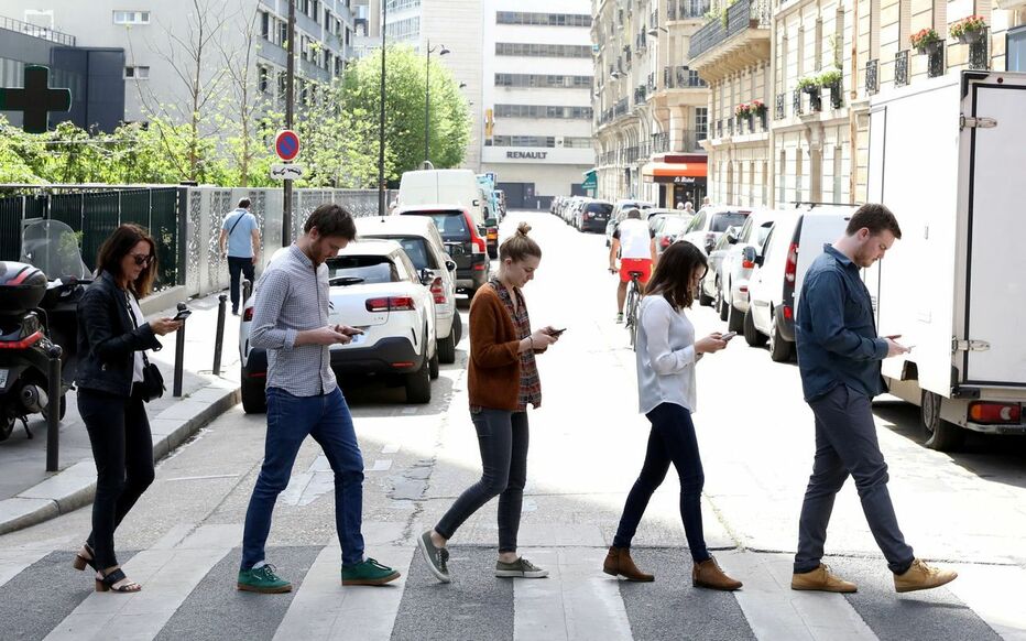 People-crossing-street-each-with-cell-phone-in-hand